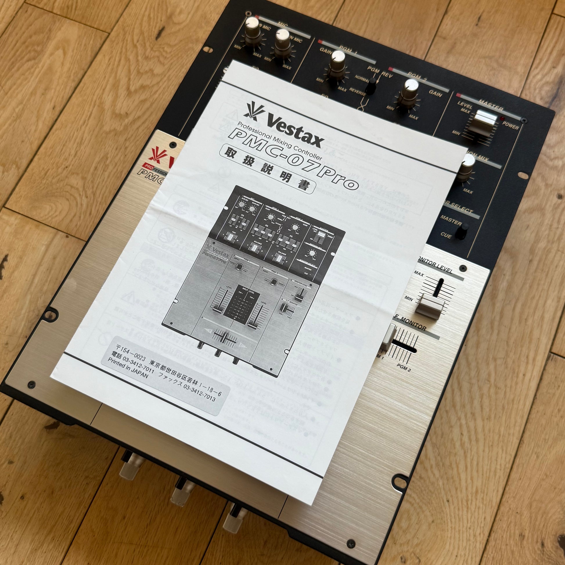 Angled view of a serviced Vestax PMC-07 Pro with original Japanese instruction manual.